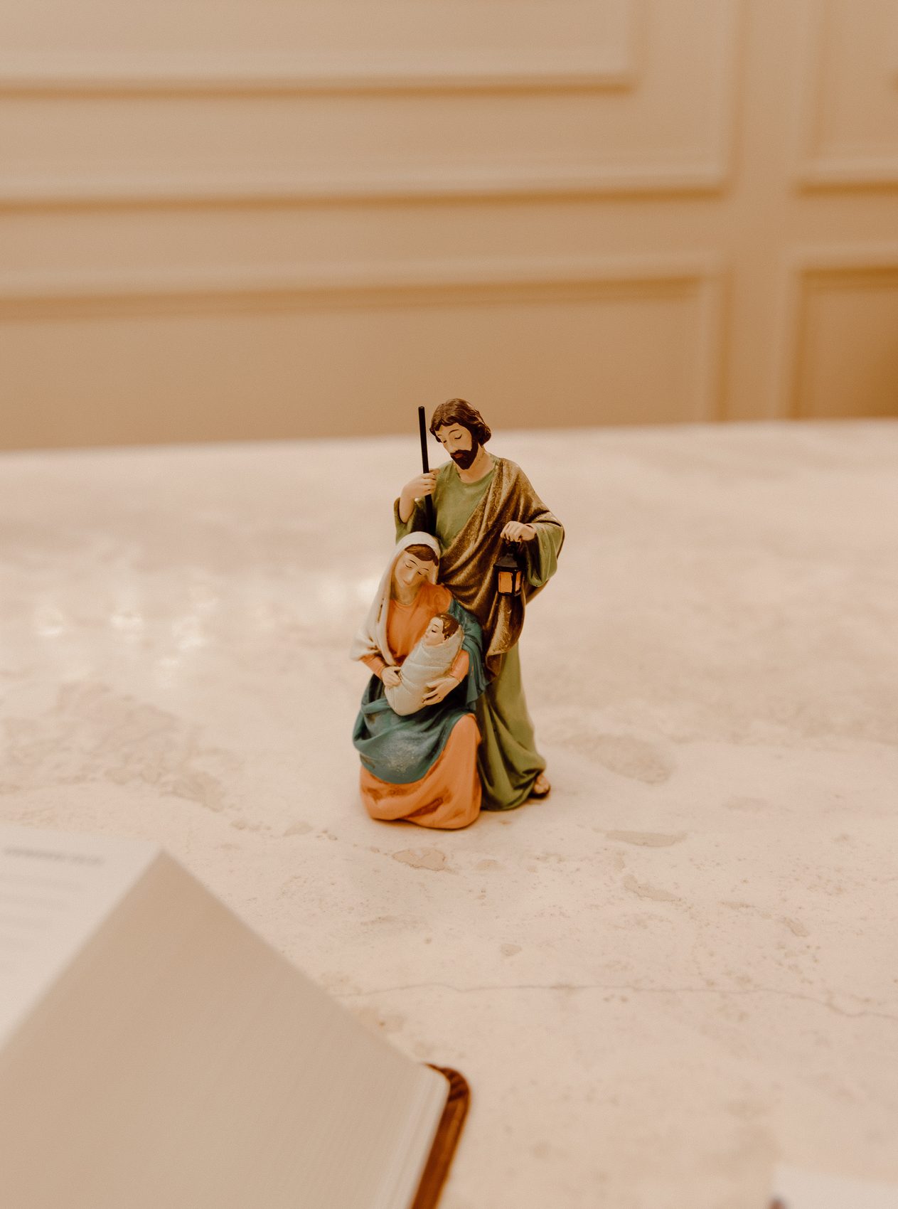 A Holy Family nativity resting beside an open Bible