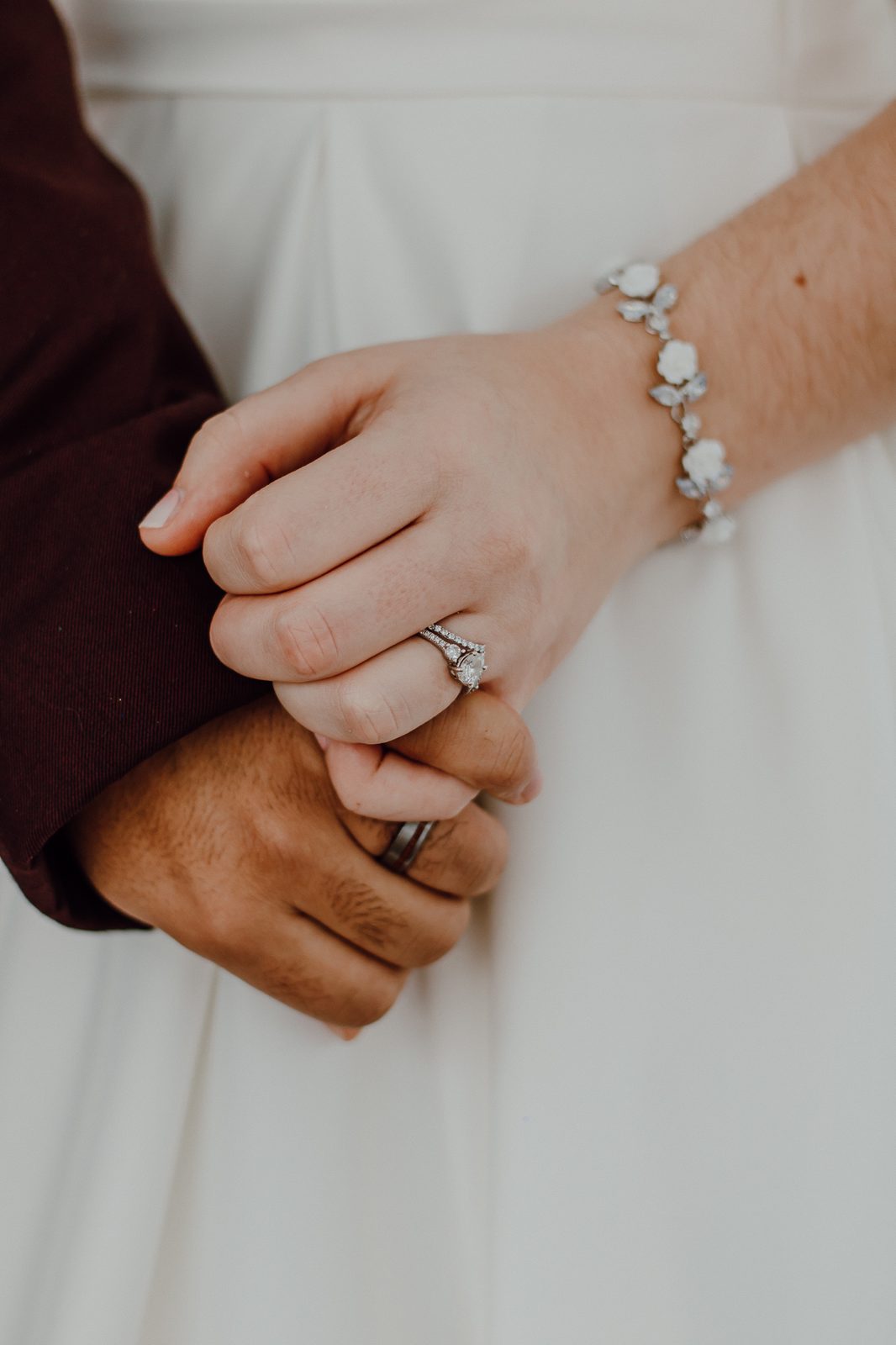 An engagement ring resting on a hand in soft light