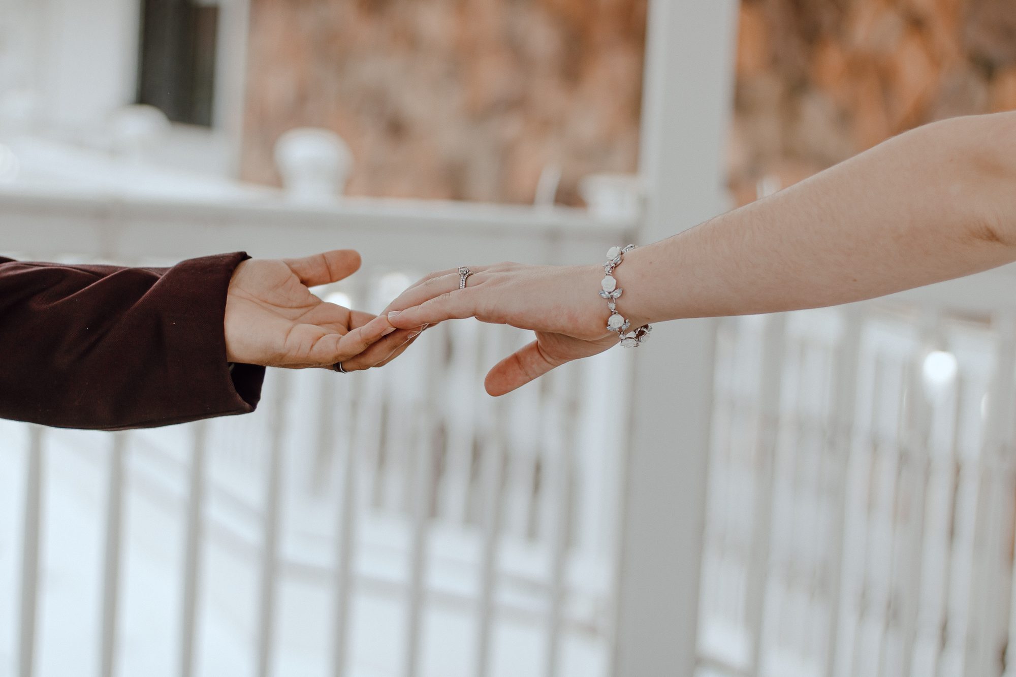 Two hands reaching toward one another in warm autumn light
